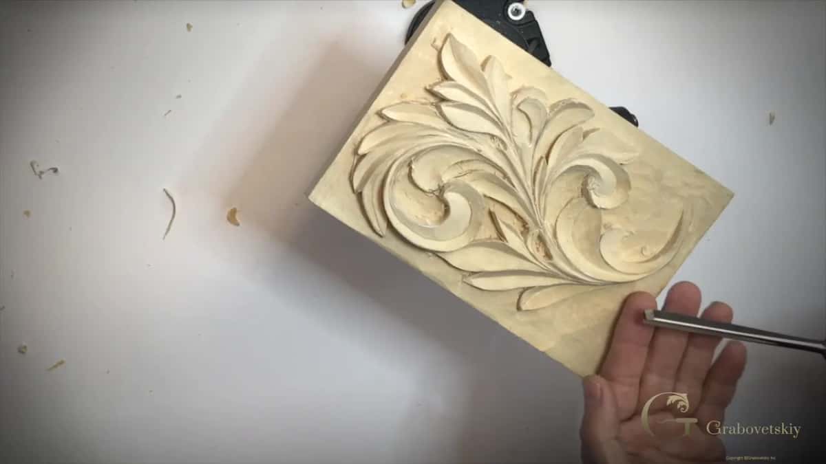 Open palm under the panel's lower edge, a steel shaft lying across it
