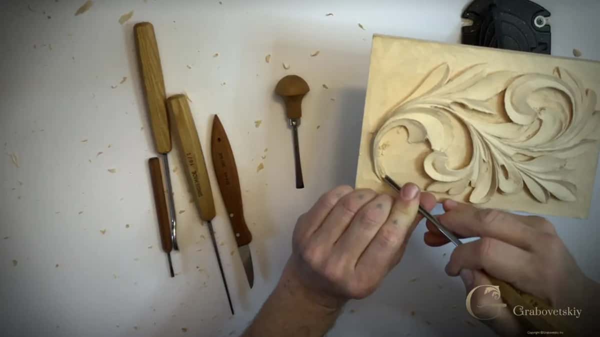 Five tools on the bench while both hands work a fine blade into the leaf