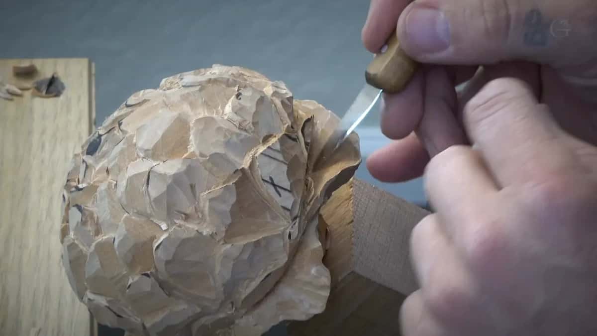 A short knife at the right side of the round flower, X marks drawn on it