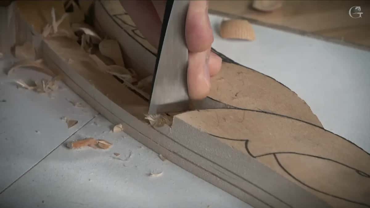 A wide flat blade stood upright on the line with a thumb behind it