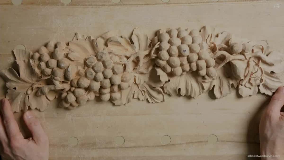 The grape onlay from above, face up, a hand at each end