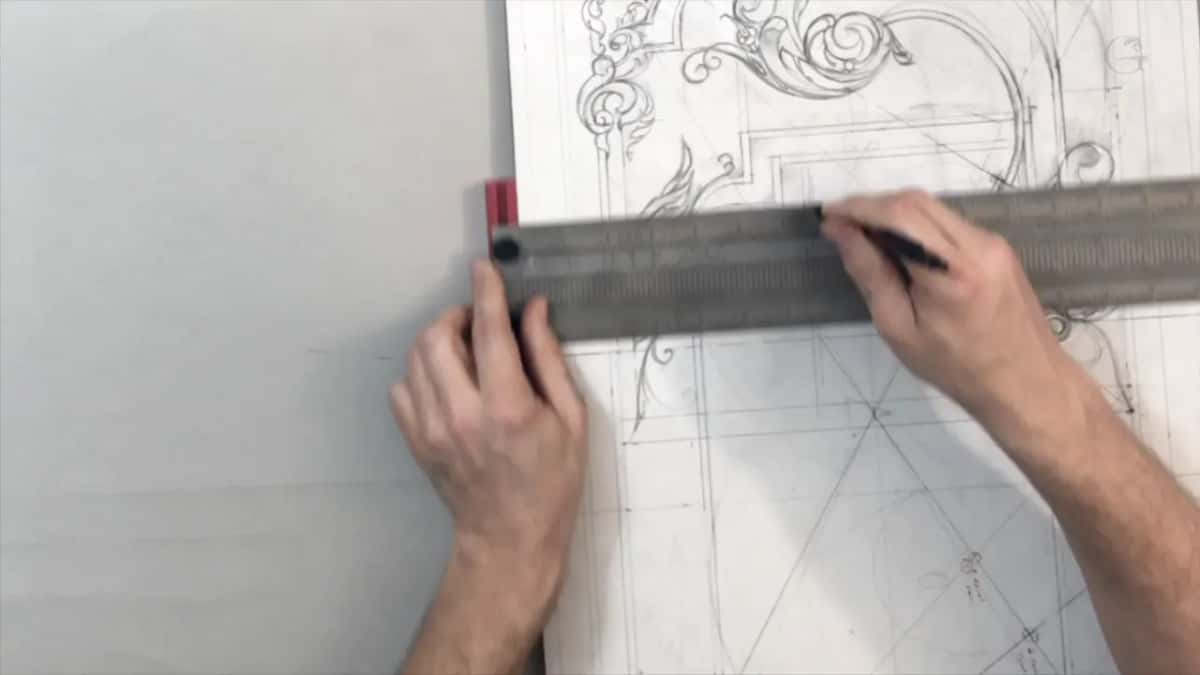 Steel rule across the paper, a pencil running along it