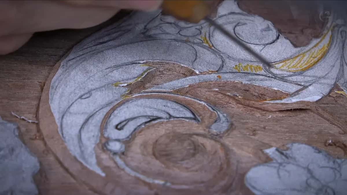 Long slim tool laid across the drawn swirl from the top right