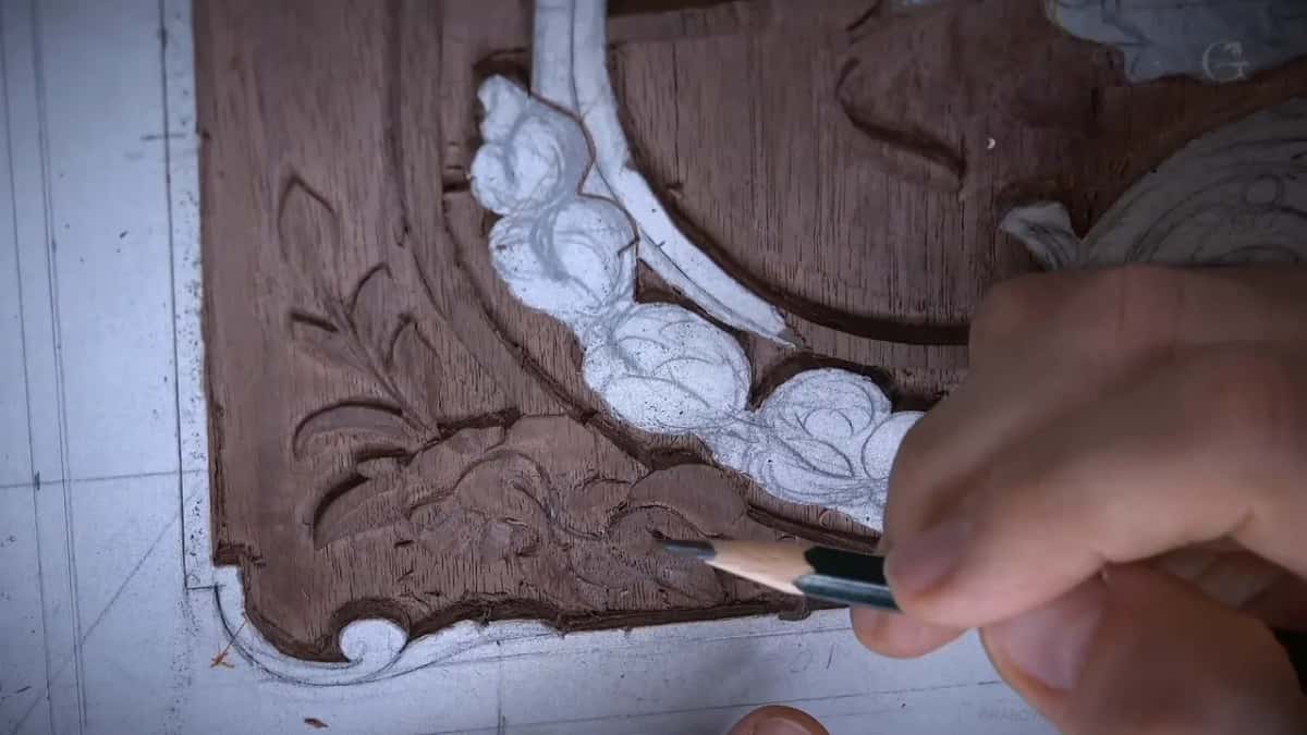 Pencil held over the corner, paper flowers to its left