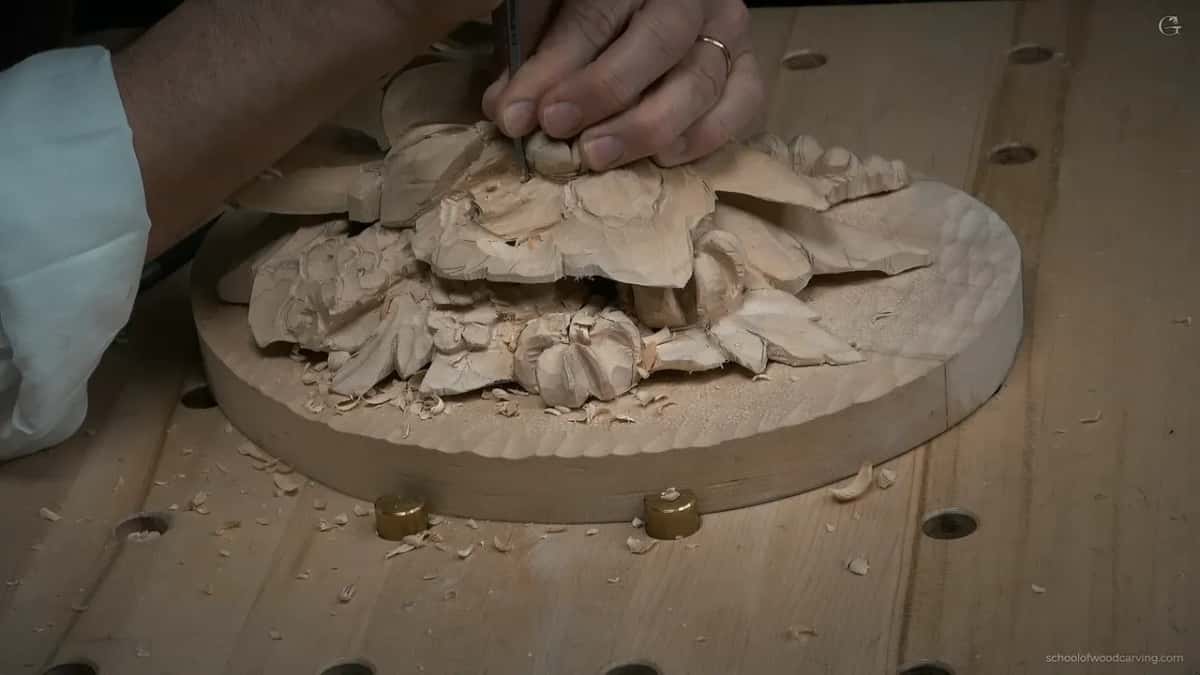 Both hands over the piece, working from above
