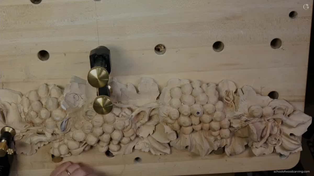 The grape panel from above, held on a bench board full of holes by two brass-topped clamps