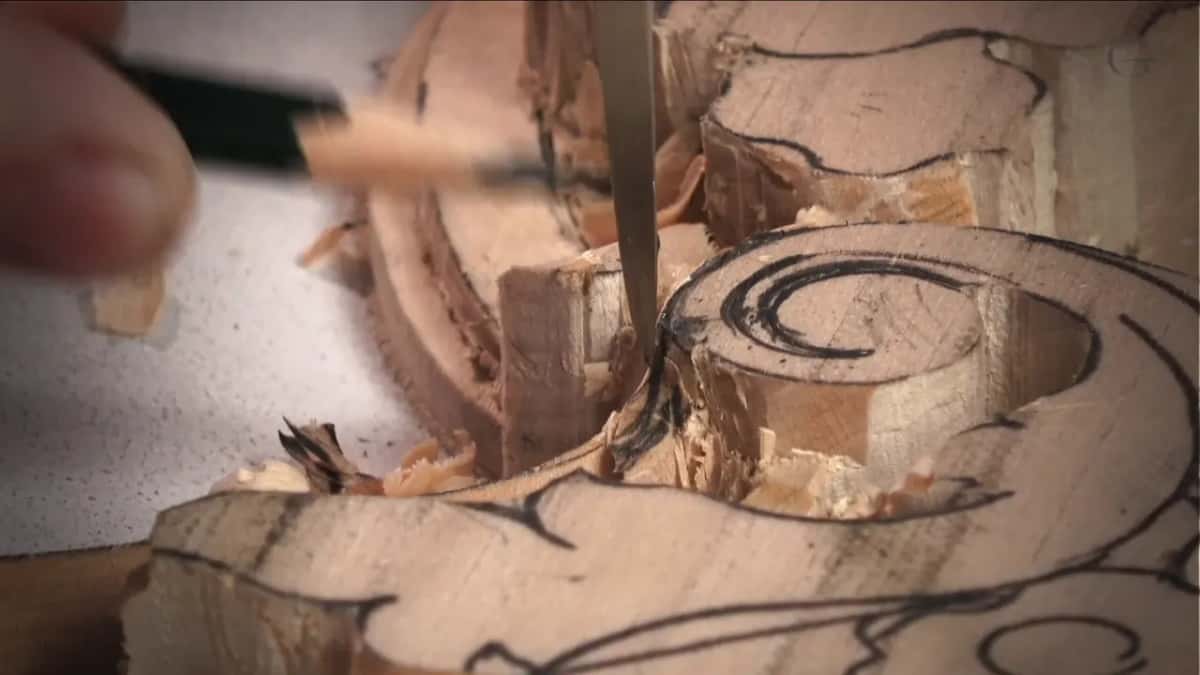 The steel rod of a depth gauge in a carved groove beside a drawn scroll, a pencil ready to mark