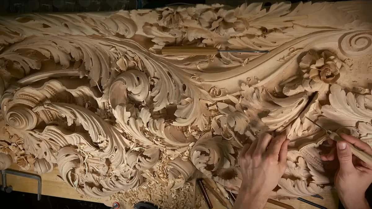 The leaf held against the big carved panel, hands on both ends