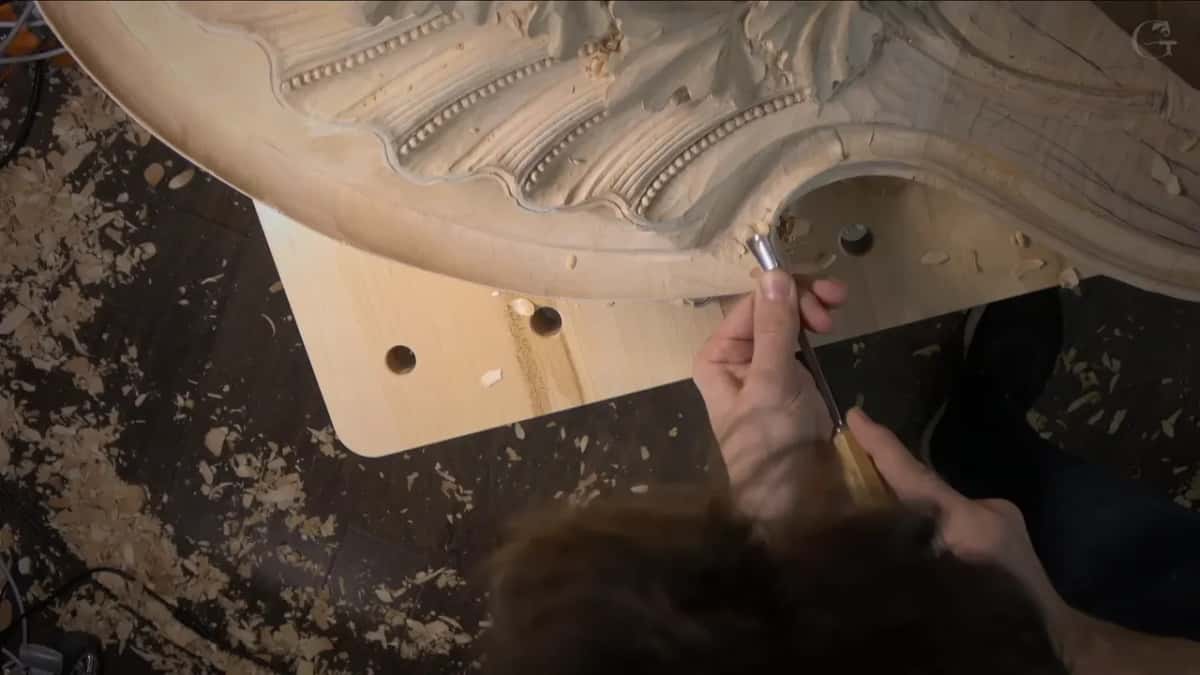 Upward push with a narrow gouge into the corner, rows of tiny beads running along the carved rays above.