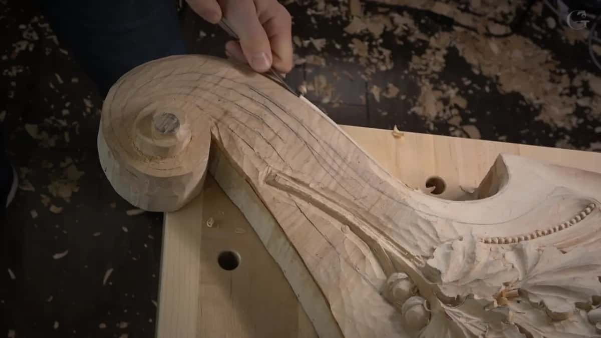 A thin tool at the scroll's upper curve.