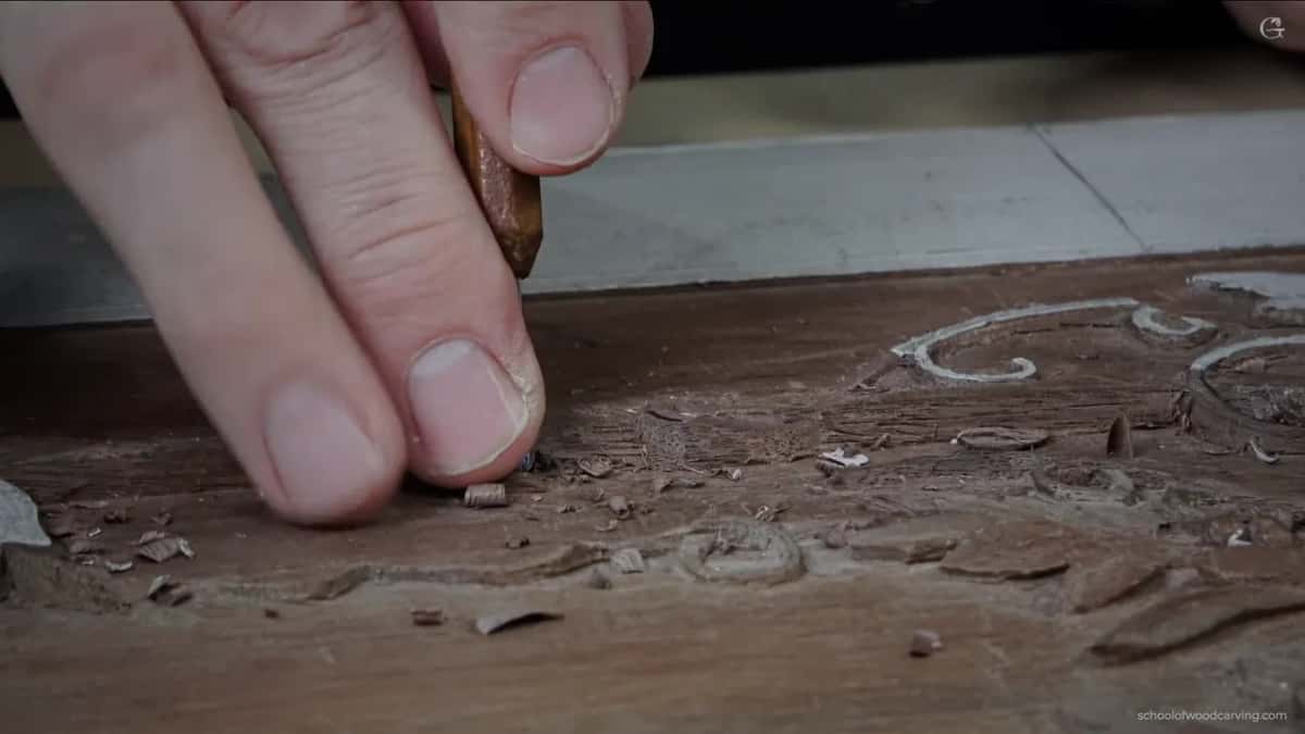 Two fingertips pressed down as a small blade goes in