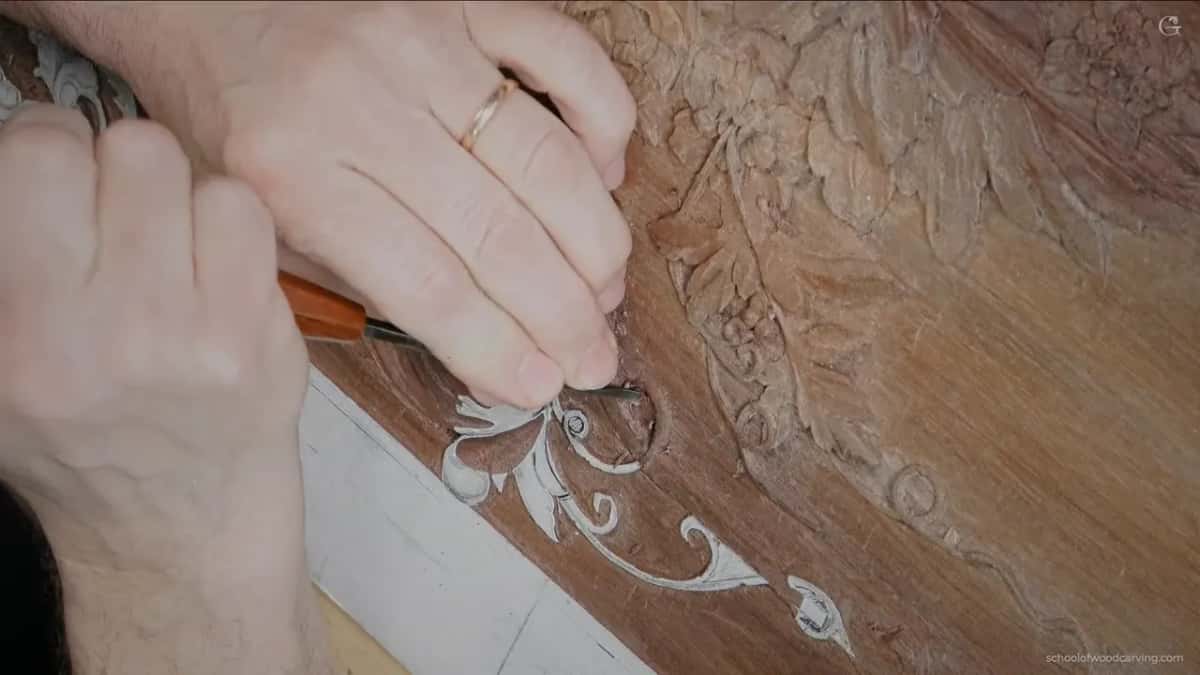 Both hands around a small tool with an orange handle