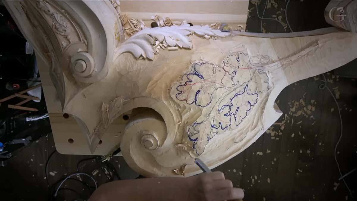 Two oak leaves drawn in blue marker beside a carved volute, their stems running off to the right