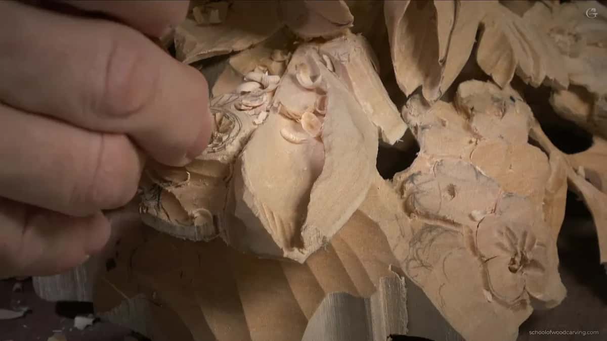 Fingers working at the center, shavings all around, the drawing still on the petals around it