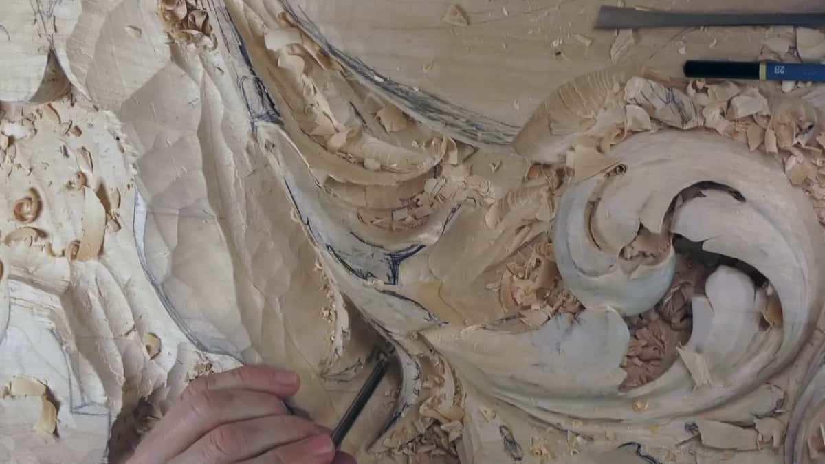 Outlining low on the leaf while two tools lie on the board above.