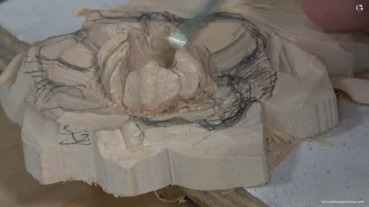 Shaped petal standing clear of the ground around it, drawing lines still visible on the wood.