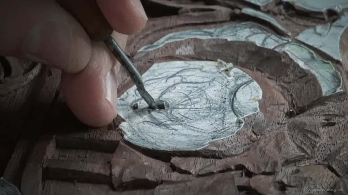 Two fingertips pinch a small gouge
