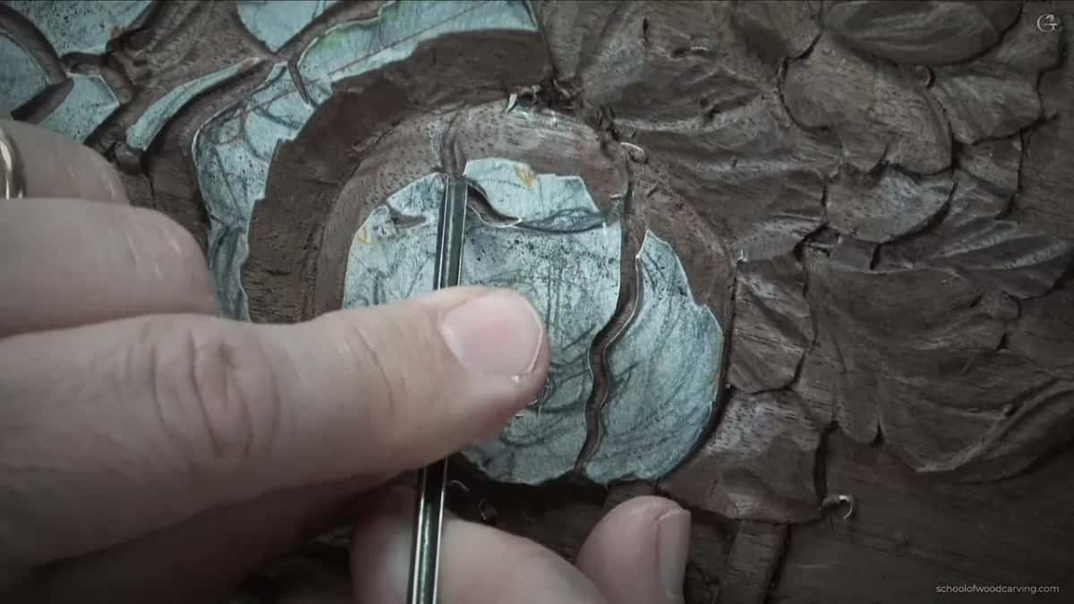 Fingers hold a slim tool upright in the petal outline
