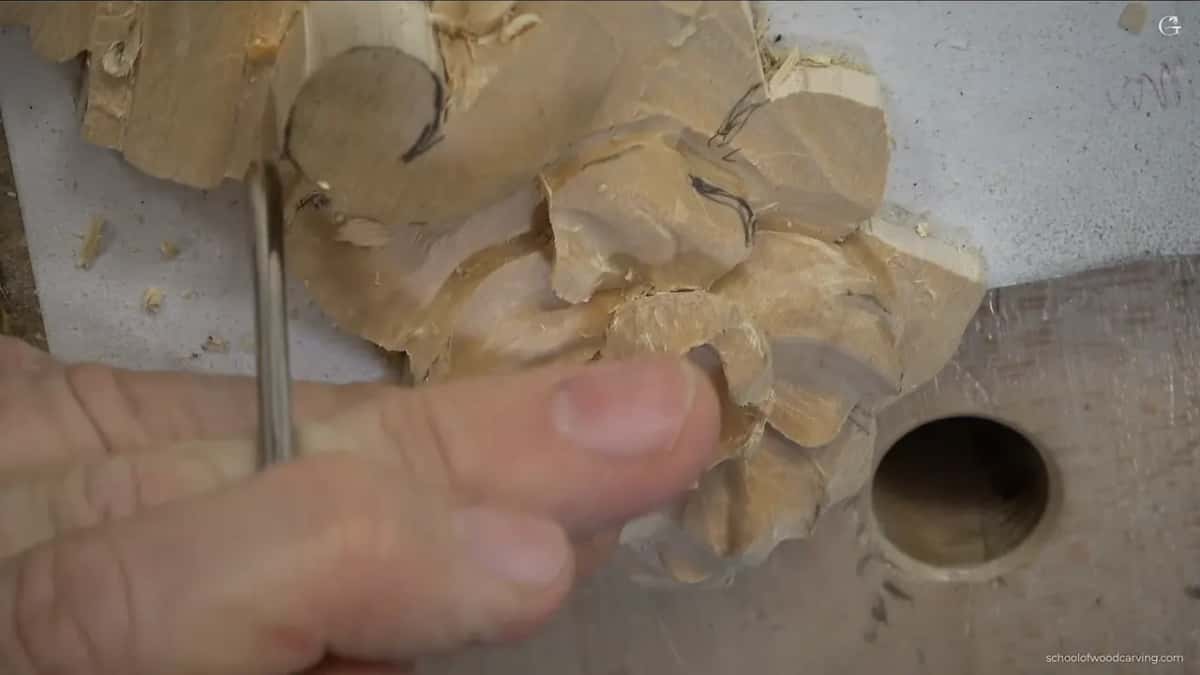 Tool held upright and pushed straight down near the round end of the scroll.
