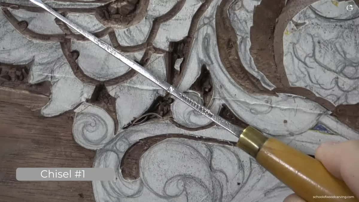 Chisel #1 label under a long chisel with a brass ferrule laid across the carving