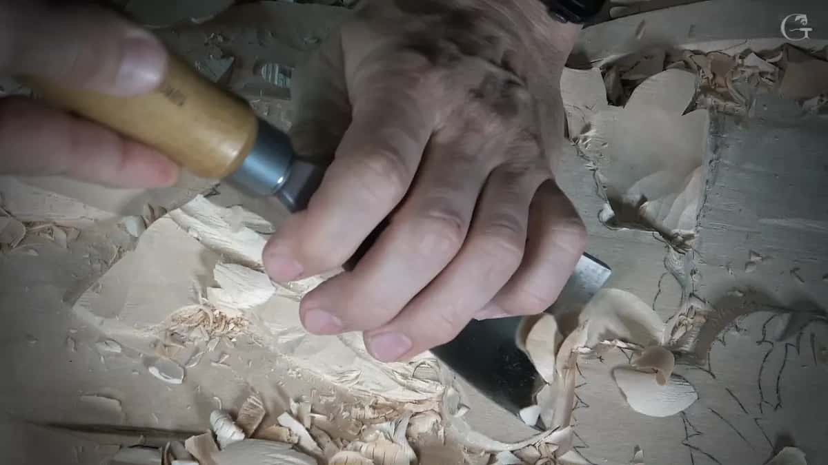 Grip on a wood handle, ferrule down, blade in the chips