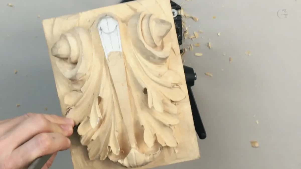 One hand at the lower left edge of the upright panel, paper strip on top