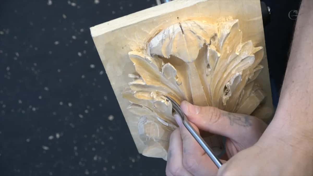 Panel stood upright against the floor while one hand works a tool along the bottom of the leaf