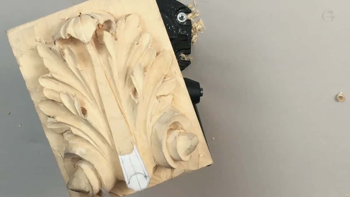Upright on its end in the vise, the panel stands among scattered chips