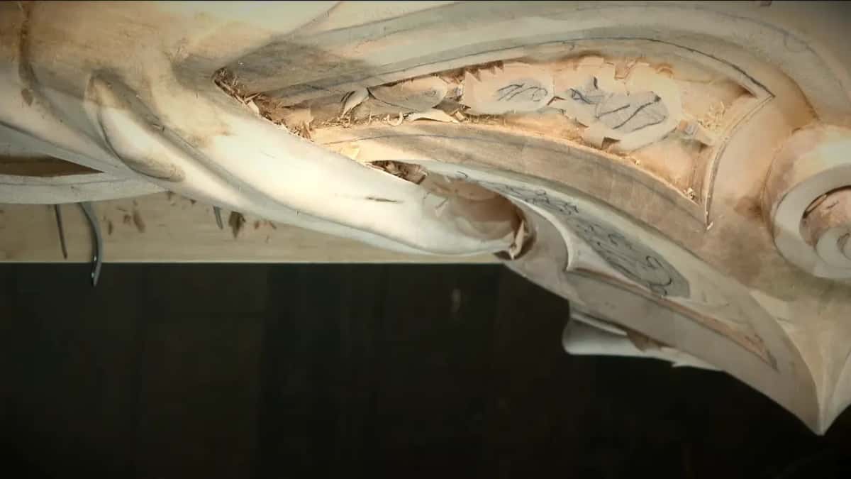 No hands in view, the lower edge now rounded like a bead under the panel with its drawn leaves