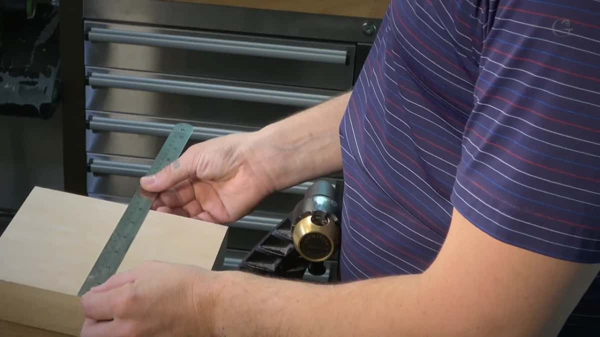 Steel rule laid across a pale board, a brass knob behind it