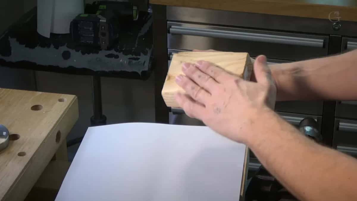 Hands on a scrap block over white paper