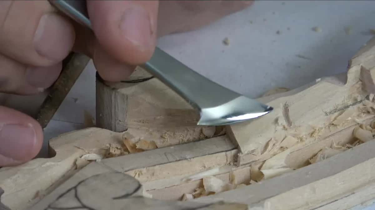 A bent steel blade beside the round volute, and shavings everywhere.
