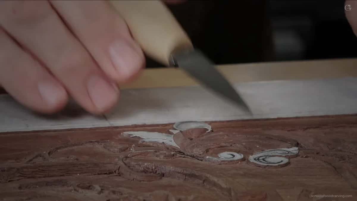 Pale handled knife at bench level, its blade angled down at the paper