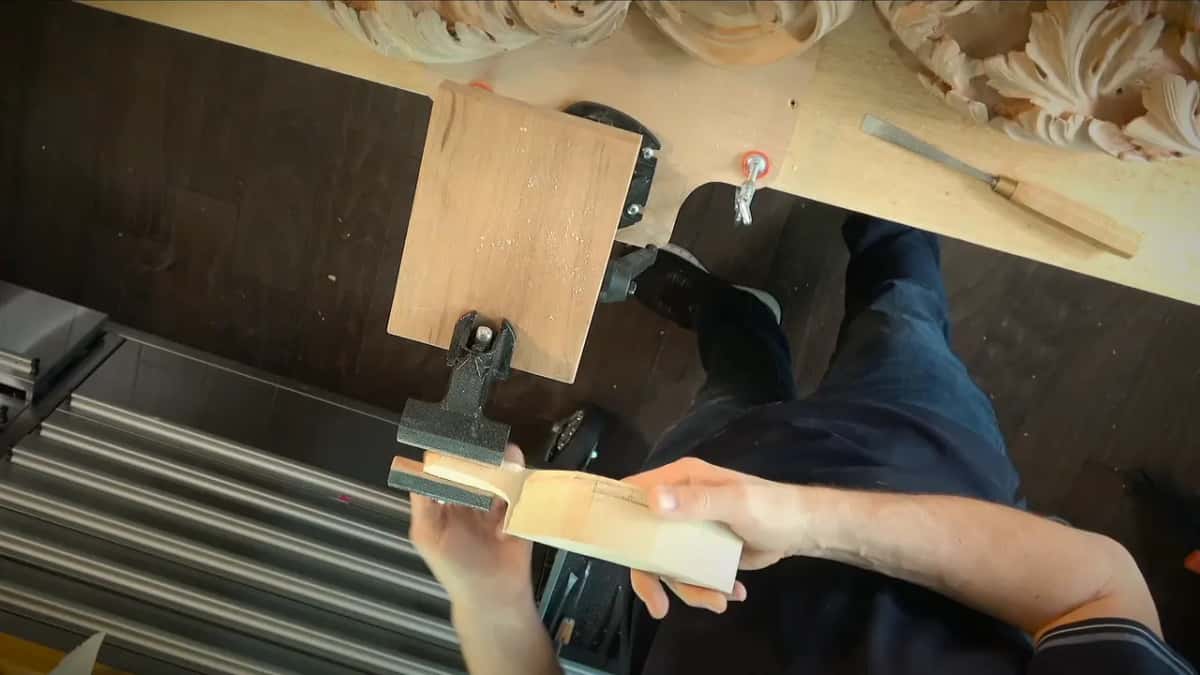 Sawn stem piece clamped in the small vise, a gouge resting on the bench