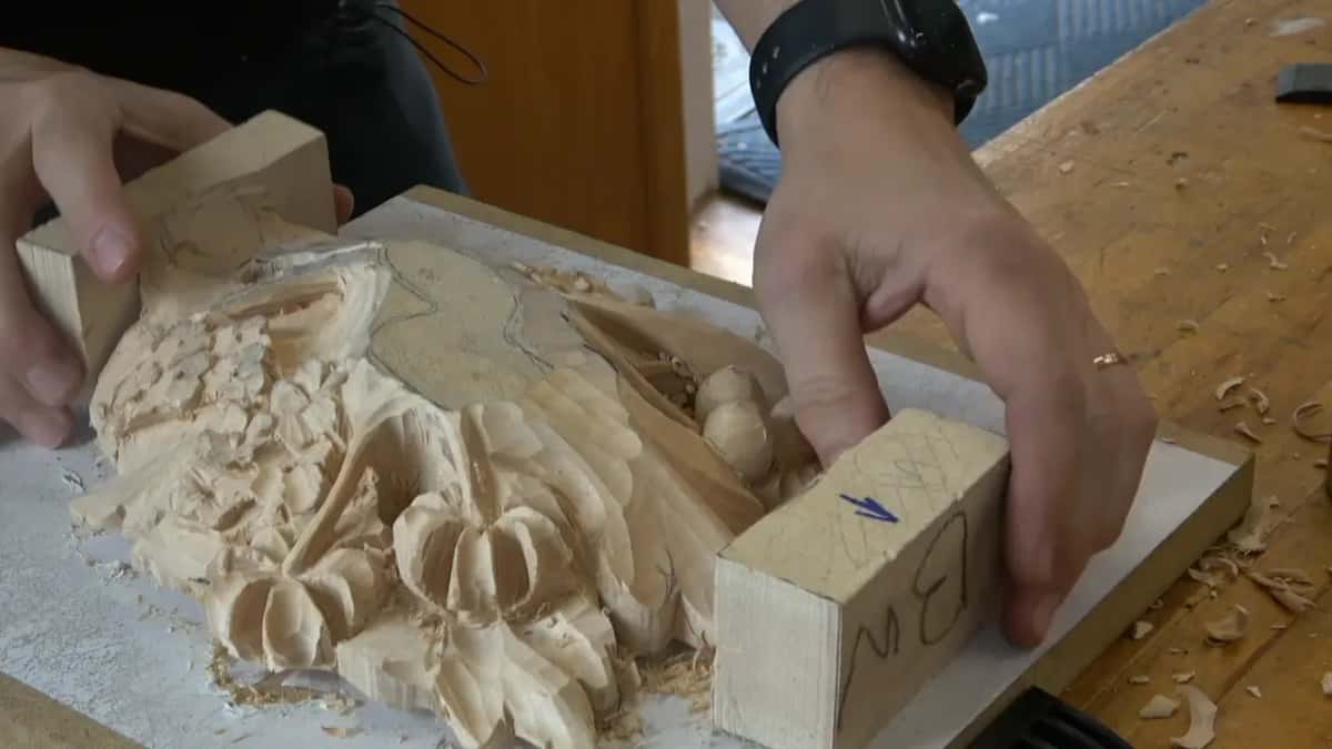 Face up between its end blocks, the carved layer, with a blue arrow drawn on the near block