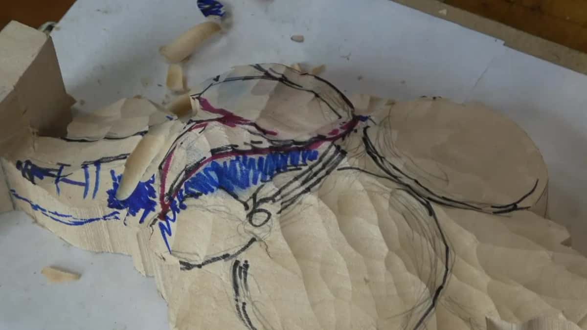 Red and blue ink soaked into the grain at the edge of the blank, a loose curl beside it