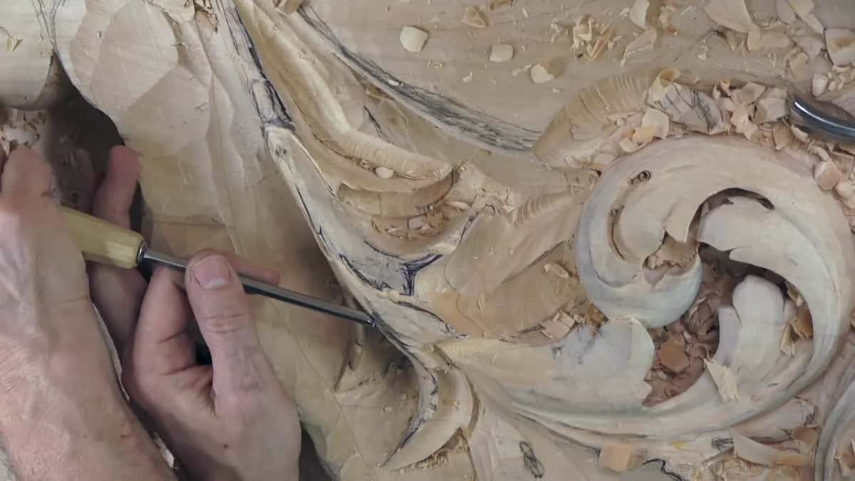 Both hands push a long, thin veiner along the rim of a lobe.