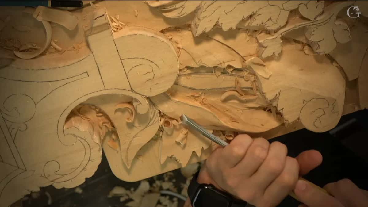 Gouge set against the edge of a leaf, next to a drawn scroll.