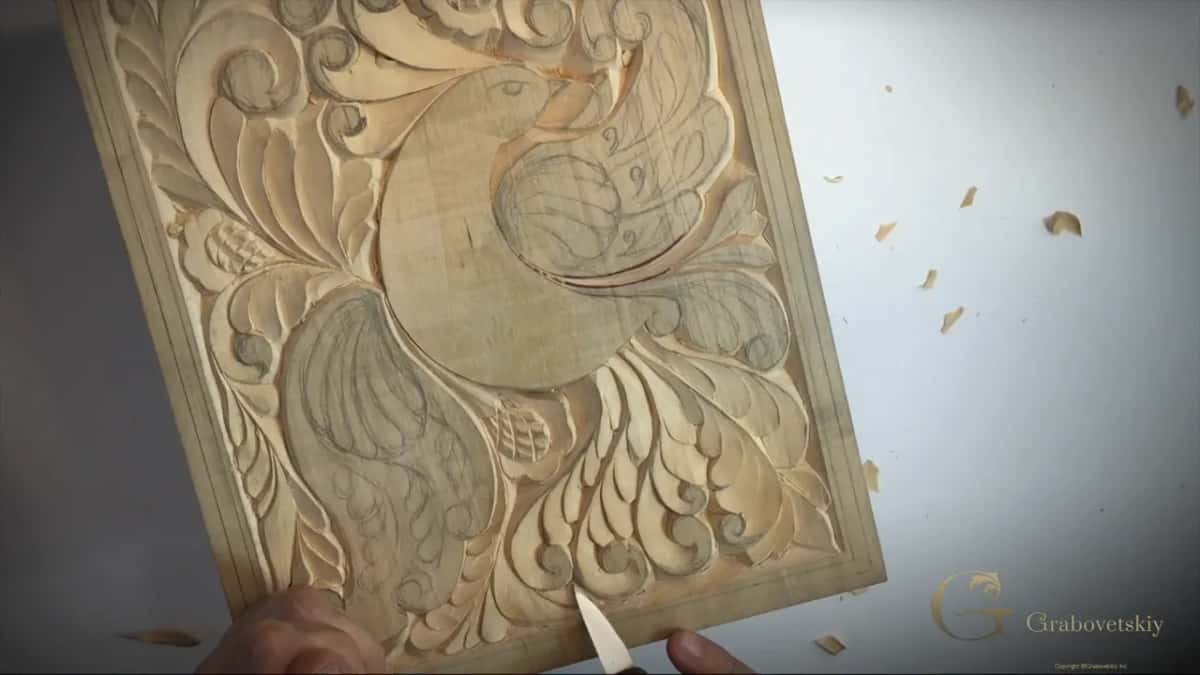 Whole bird panel from above with wood chips scattered on the white table and the blade tip at the bottom