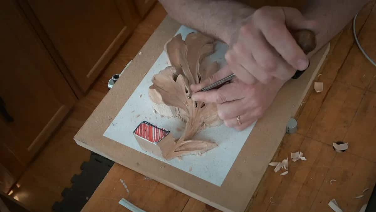 Seen from overhead, both arms reach in and a thin tool sits at the very top of the leaf