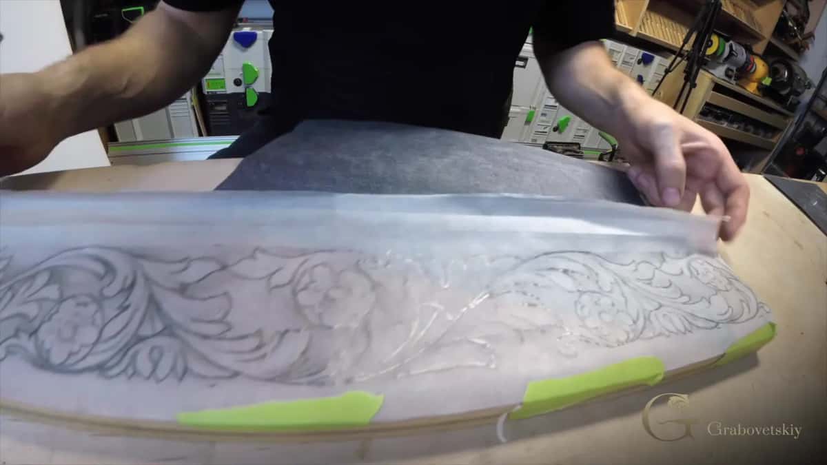 Tracing paper lifted at one end, green tape still holding the rest down