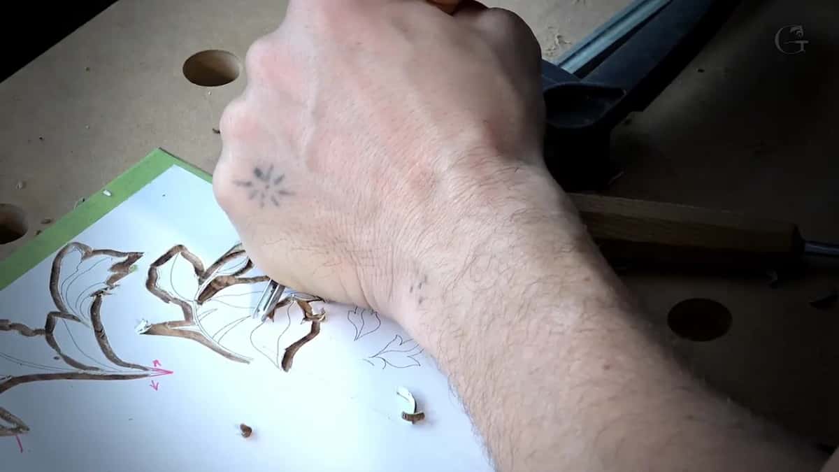 One forearm over a paper pattern, two small chips lying near it