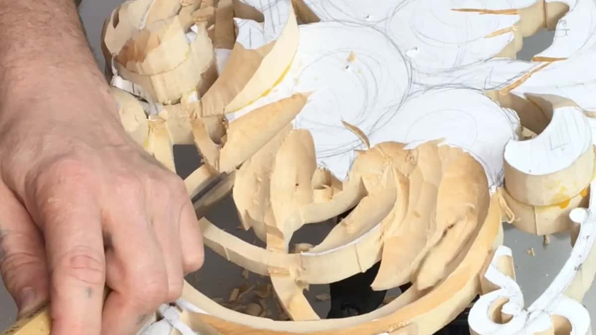 Close over the work, a hand grips the handle low while the blade slips in between two thick leaves.
