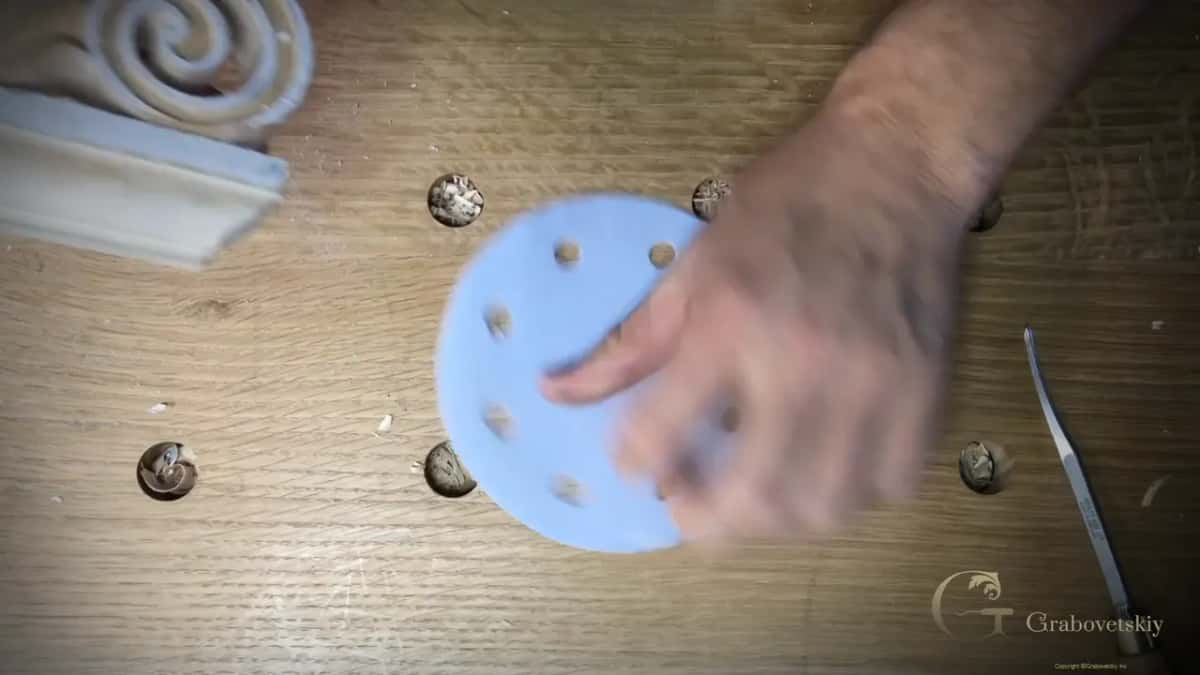 Round blue sanding pad held flat next to the base