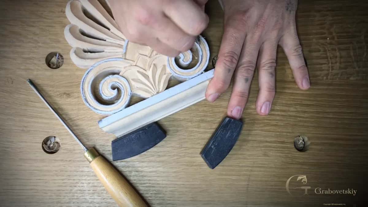 Fingers press down on the fan as a short tool works into the right spiral