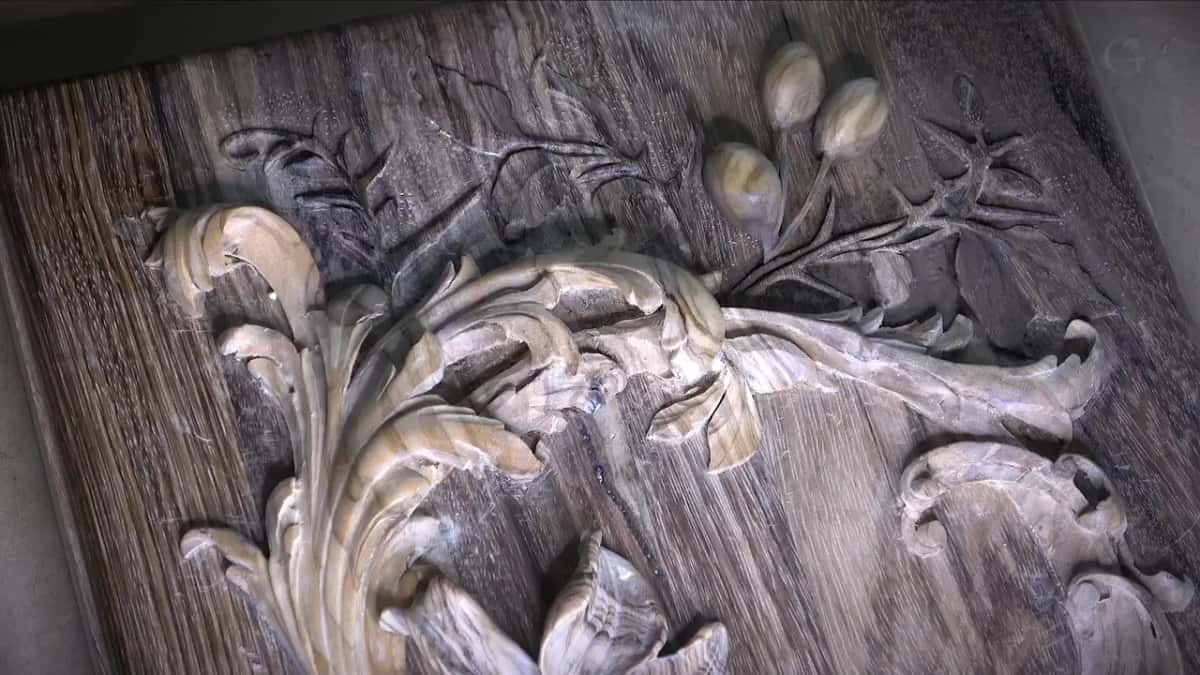 Seen from above, the tinted lid with its lily, olives and acanthus scrolls on dark streaked grain