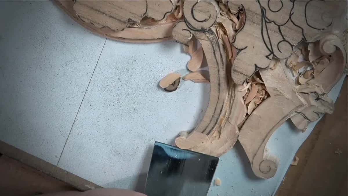 Wide flat blade resting at the foot of the long curve, fresh chips curled beside it