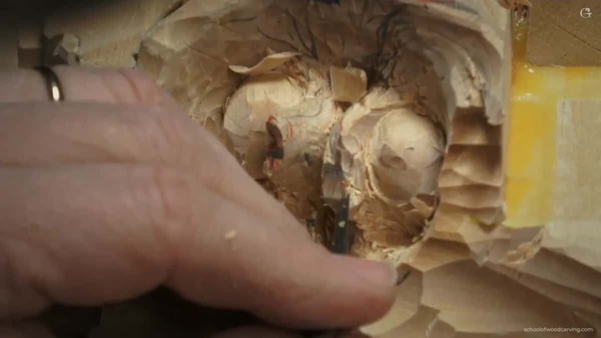 Edge pushed down between the two nuts under an open hand