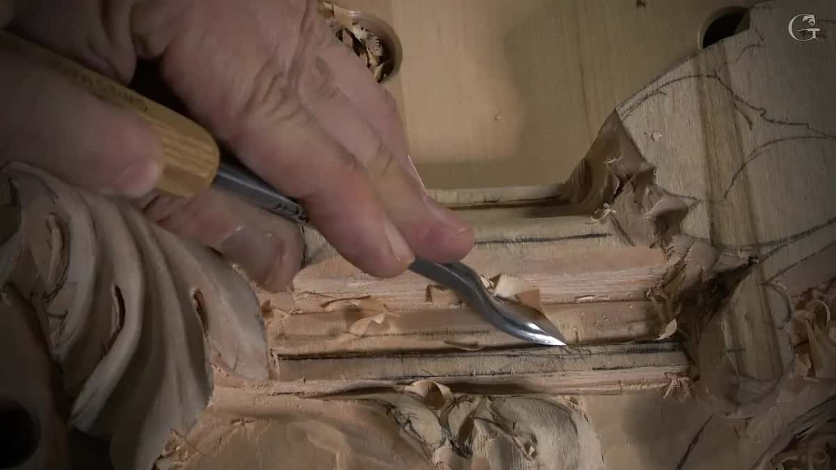 Held low in the fingers, a back bent runs along a narrow molding strip with curls of wood