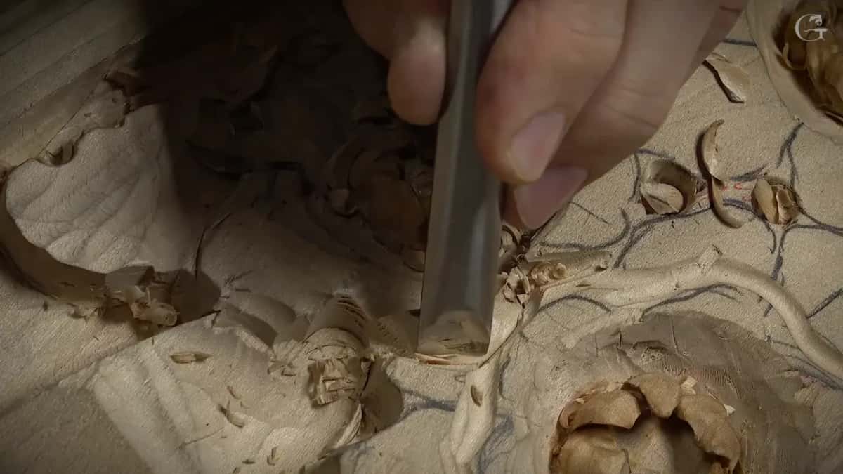A flat gouge stands upright in a hollow at the edge of one big petal